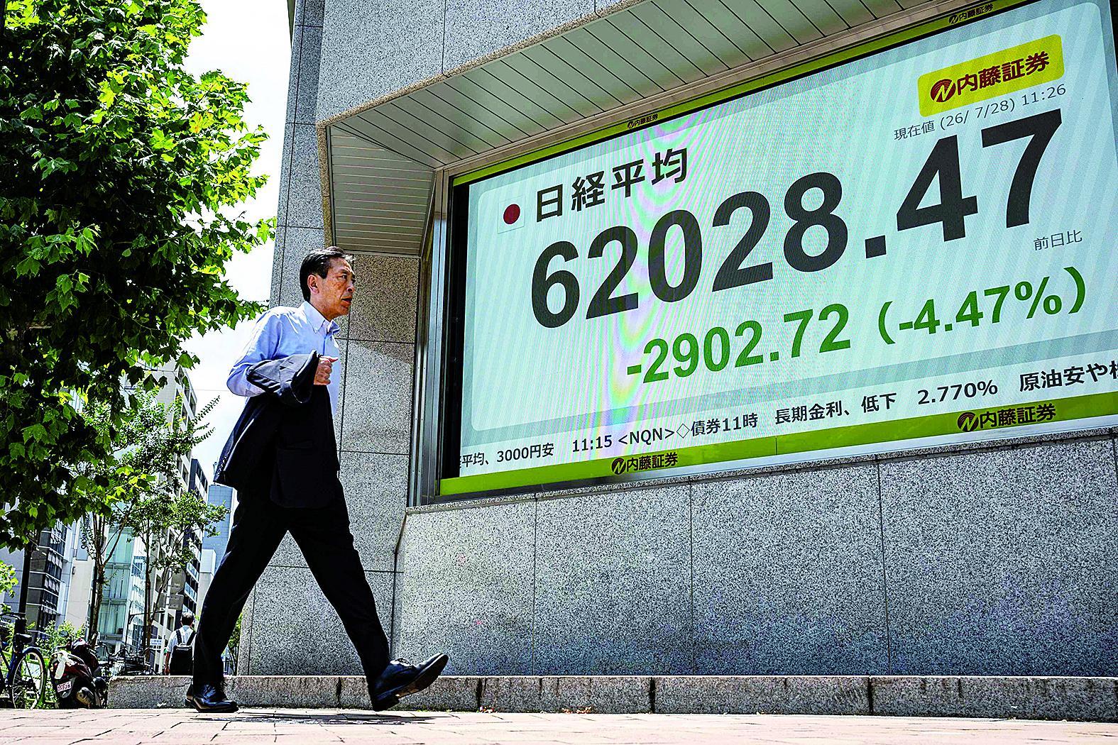 行人经过日本东京一处电子股指显示屏 新华社发